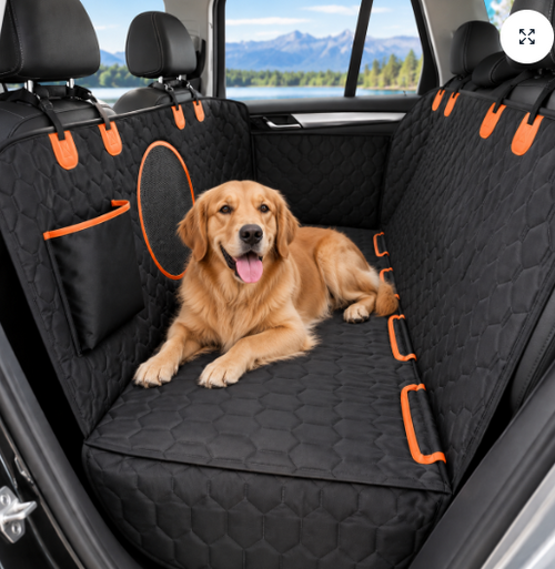 Cubreasiento negro tipo hamaca para perros con detalles naranjas instalado en el asiento trasero de un auto.