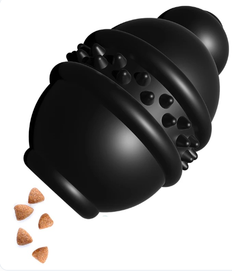 Juguete dispensador de premios negro, con cuerpo redondeado, surcos y relieves, junto a pequeñas piezas de alimento.